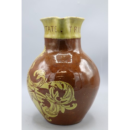 1060 - North Devon slipware harvest jug, scrolled handle, inscribed 'IN VERITATE TRIUMPHO', dated 1904, H24... 