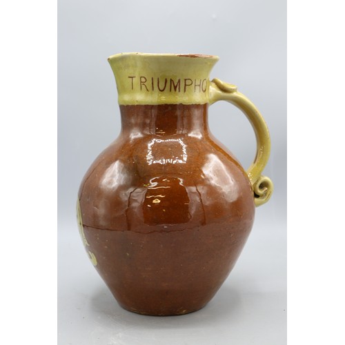 1060 - North Devon slipware harvest jug, scrolled handle, inscribed 'IN VERITATE TRIUMPHO', dated 1904, H24... 