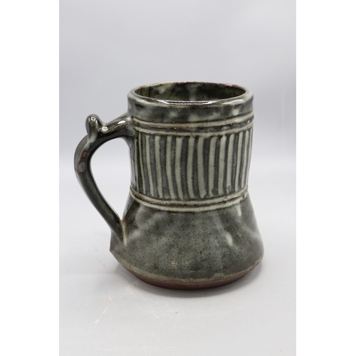 1090 - Abuja Pottery stoneware tankard, cylindrical spread form, blue glazed, possibly Ladi Kwali, H15cm
Br... 