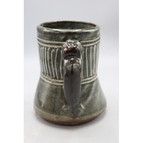 1090 - Abuja Pottery stoneware tankard, cylindrical spread form, blue glazed, possibly Ladi Kwali, H15cm
Br... 
