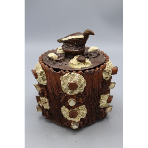 1012 - Barkware tobacco jar with alternate coloured appliques and bird finial, and a bark-ware money box, s... 