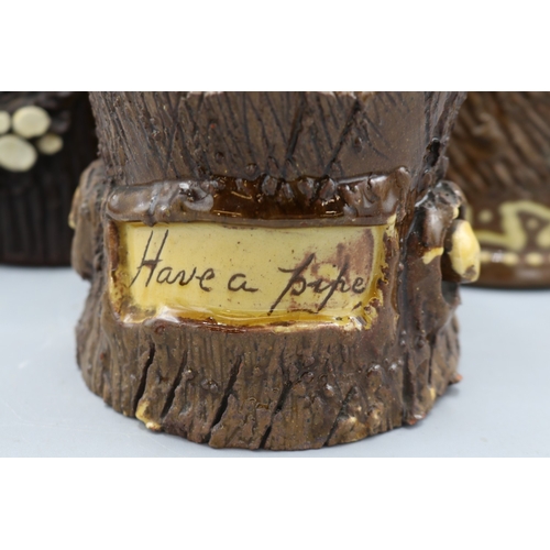 1019 - Three barkware tobacco jars of varying sizes, one in dark treacle type glaze with applied branch stu... 