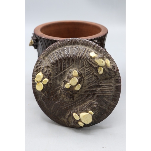 1019 - Three barkware tobacco jars of varying sizes, one in dark treacle type glaze with applied branch stu... 