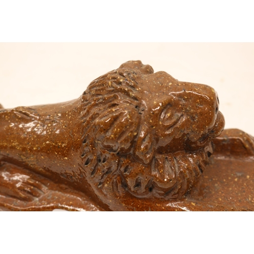 1077 - 19th century stoneware slat glazed lion atop plinth base and a stoneware dog figure with bowl on a s... 