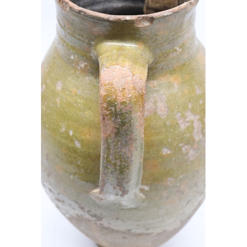 1075 - 18th Century terracotta squat baluster water jug with green glazed and incised ribbing, possibly con... 