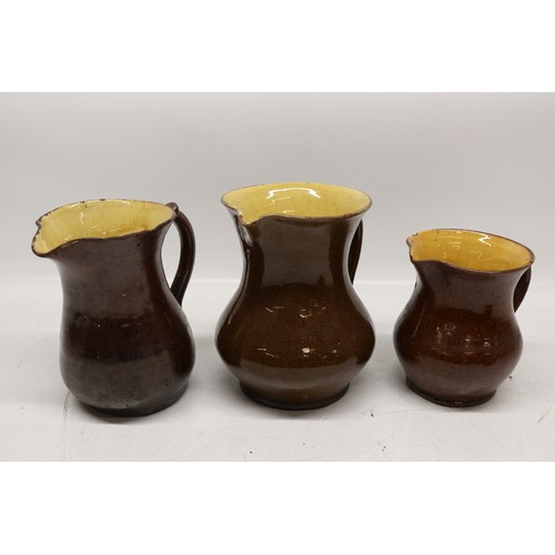 1029 - Five Yorkshire slipware jugs, yellow internal glaze, of varying sizes, in the manner of Isaac Button... 