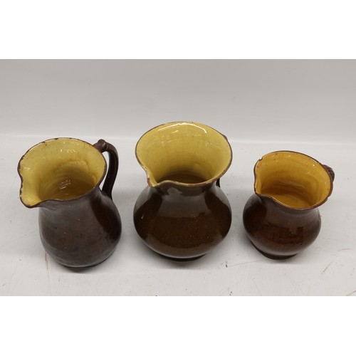 1029 - Five Yorkshire slipware jugs, yellow internal glaze, of varying sizes, in the manner of Isaac Button... 