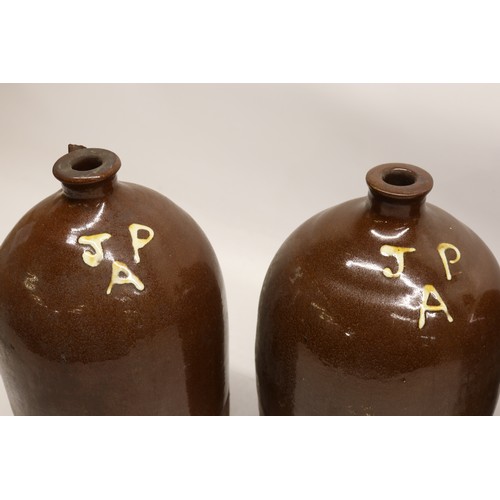 1046 - Four J.P. Appleby slipware flagons, treacle glazed, necked cylindrical form, three initialled 'JPA' ... 