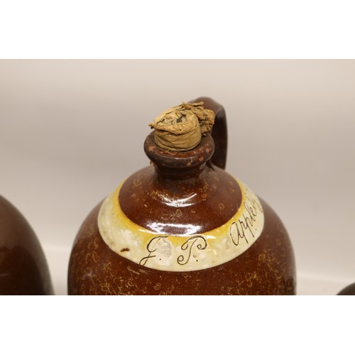 1046 - Four J.P. Appleby slipware flagons, treacle glazed, necked cylindrical form, three initialled 'JPA' ... 