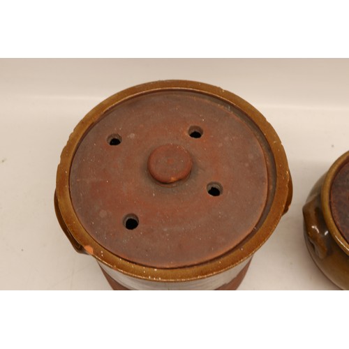 1056 - Two Yorkshire slipware crocks or cooking pots, one cylindrical and the other squat baluster, both pa... 