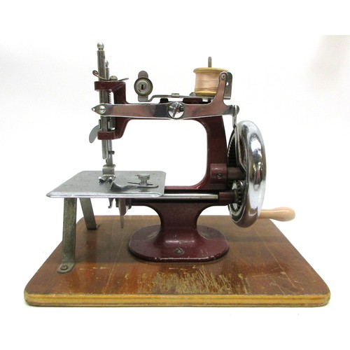 Miniature red sewing machine c1940-50s; portable hand-operated chain ...