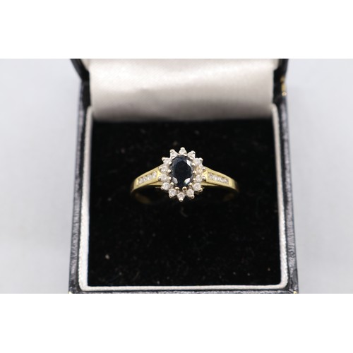 1 - Hallmarked 18ct yellow gold sapphire diamond halo cluster ring. 1x central oval cut dark blue sapphi... 