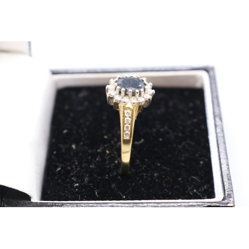 1 - Hallmarked 18ct yellow gold sapphire diamond halo cluster ring. 1x central oval cut dark blue sapphi... 