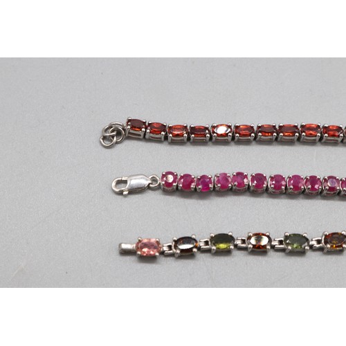 32 - Silver lot comprising three hallmarked sterling silver tennis bracelets: one round brilliant-cut rub... 