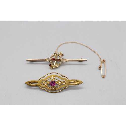 33 - Two gold brooches comprising one stamped 9ct rose gold bar brooch set with four garnets and seed pea... 