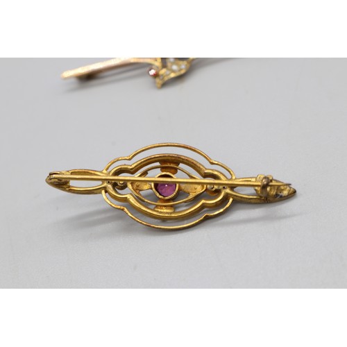 33 - Two gold brooches comprising one stamped 9ct rose gold bar brooch set with four garnets and seed pea... 