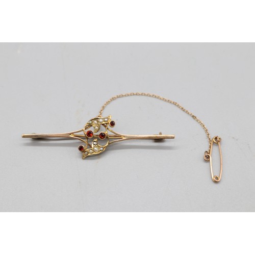 33 - Two gold brooches comprising one stamped 9ct rose gold bar brooch set with four garnets and seed pea... 