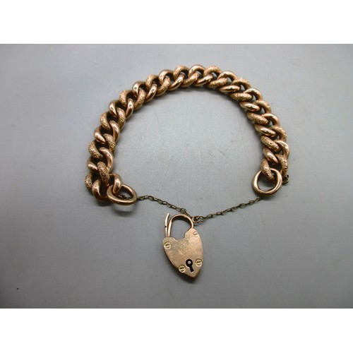 54 - Hallmarked 9ct yellow gold curb chain bracelet with engraved links and padlock style clasp with safe... 