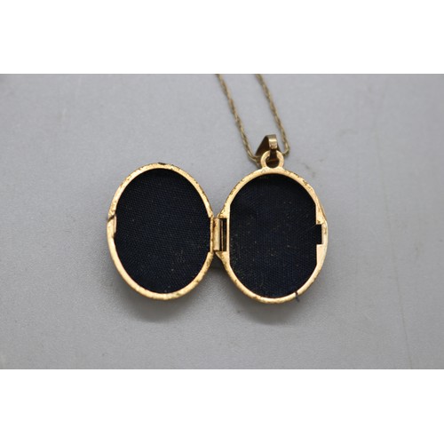 43 - Lot comprising two gold pendants and chains, including a stamped 14ct oval ruby and diamond halo pen... 