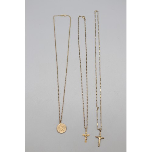 41 - Lot of three 9ct yellow gold religious pendants and chains, comprising a stamped 9ct yellow gold cru... 