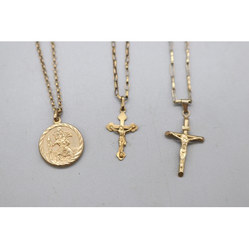 41 - Lot of three 9ct yellow gold religious pendants and chains, comprising a stamped 9ct yellow gold cru... 