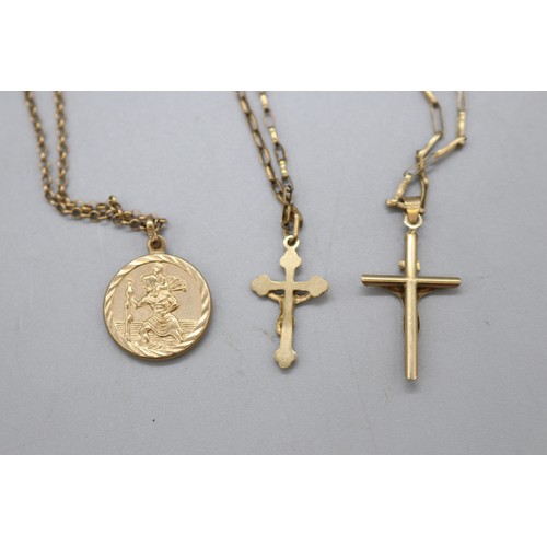 41 - Lot of three 9ct yellow gold religious pendants and chains, comprising a stamped 9ct yellow gold cru... 