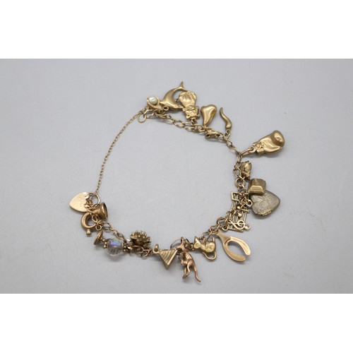 34 - Hallmarked 9ct yellow gold curb link charm bracelet with padlock clasp, set with the following charm... 
