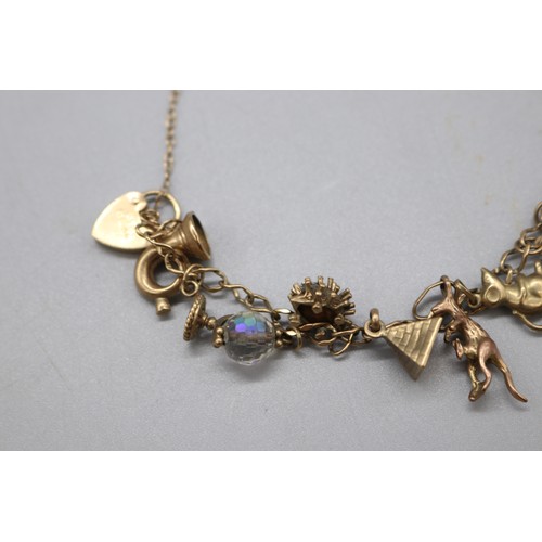 34 - Hallmarked 9ct yellow gold curb link charm bracelet with padlock clasp, set with the following charm... 