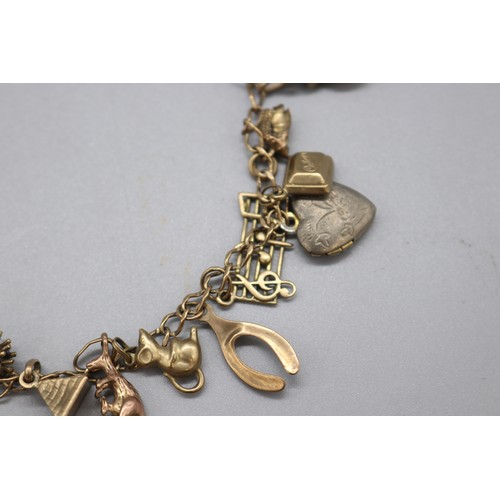 34 - Hallmarked 9ct yellow gold curb link charm bracelet with padlock clasp, set with the following charm... 