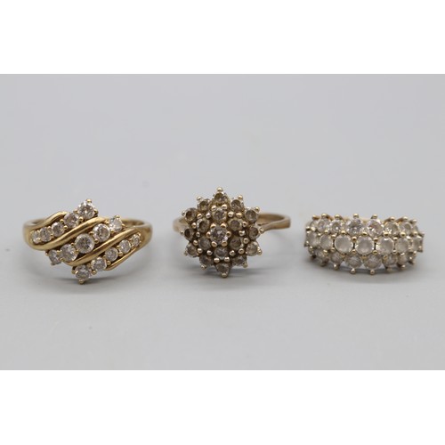 27 - Three hallmarked 9ct yellow gold cubic zirconia cluster rings, comprising a hexagonal flower cluster... 