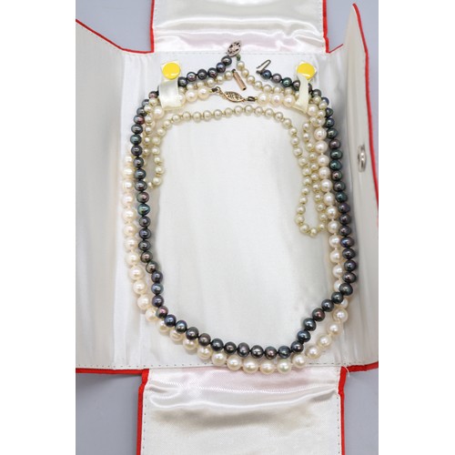 56 - Lot of three pearl necklets, comprising an individually strung white pearl necklet with stamped 10k ... 