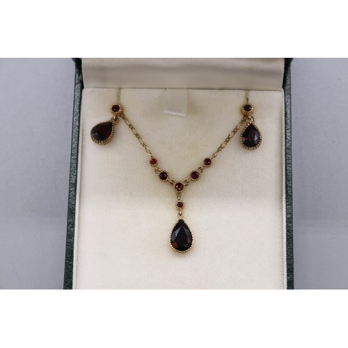 10 - Stamped 9ct yellow gold garnet pendant and earrings set, comprising a hallmarked 9ct seven-stone gar... 