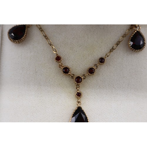 10 - Stamped 9ct yellow gold garnet pendant and earrings set, comprising a hallmarked 9ct seven-stone gar... 