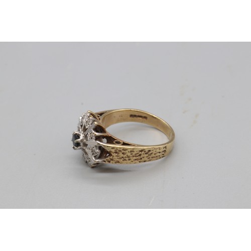 10 - A hallmarked 9ct yellow gold sapphire and diamond cocktail ring, set with a central round-cut sapphi... 