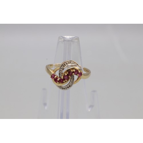 A hallmarked 9ct yellow gold ruby and diamond cocktail ring, designed with a twisted wave motif. Ring size S. Total weight 3.17g