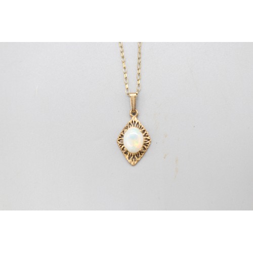 12 - A hallmarked 9ct yellow gold opal pendant and earring suite, comprising a pair of oval opal rope-edg... 