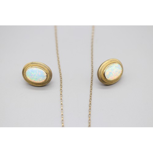 12 - A hallmarked 9ct yellow gold opal pendant and earring suite, comprising a pair of oval opal rope-edg... 