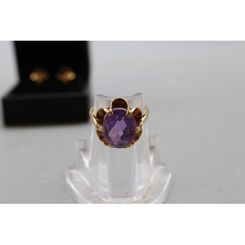 32 - A hallmarked 9ct yellow gold amethyst suite, comprising a petal-set cocktail ring with a large facet... 