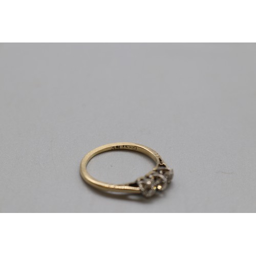 17 - A stamped 18ct yellow gold diamond trilogy ring with platinum head, set with three old round-cut dia... 