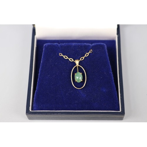 38 - A hallmarked 9ct yellow gold cabochon jade pendant on a hallmarked 9ct yellow gold flat belcher link... 