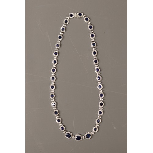 Stamped 18ct white gold sapphire and diamond collarette necklace, set with 34 oval-cut faceted blue sapphires totalling approximately 16.1ct, and 462 round brilliant-cut diamonds totalling approximately 9.9ct. Length approximately 17 inches. Total weight 44.87g