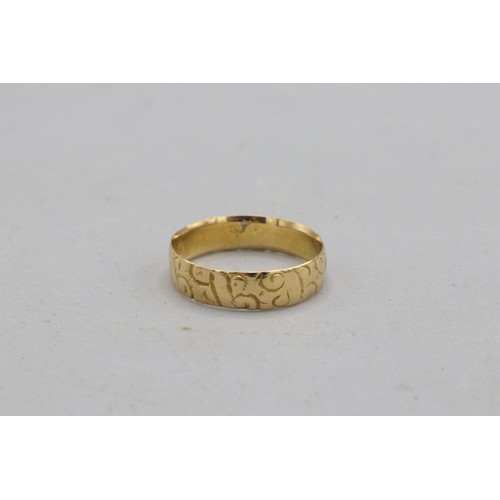 22 - Hallmarked 18ct yellow gold scrollwork-engraved wedding band, 5mm thickness. Size O. Weight 2.95g
Br... 