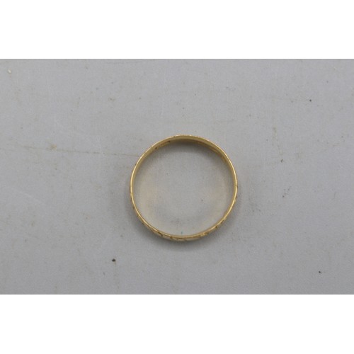 22 - Hallmarked 18ct yellow gold scrollwork-engraved wedding band, 5mm thickness. Size O. Weight 2.95g
Br... 