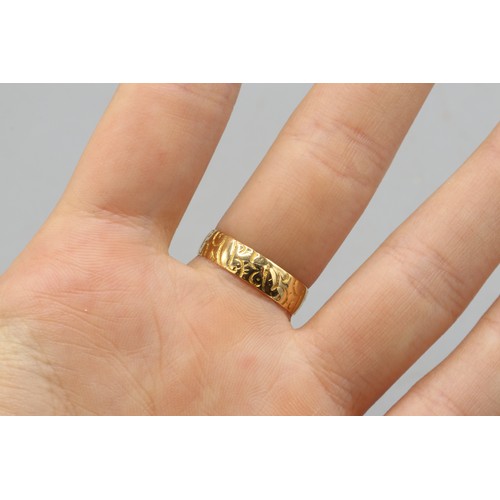 22 - Hallmarked 18ct yellow gold scrollwork-engraved wedding band, 5mm thickness. Size O. Weight 2.95g
Br... 