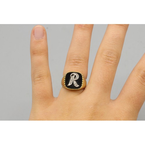 13 - Stamped 14ct yellow gold 'R' head onyx signet ring, comprised of a white gold 'R' relief head pavé-s... 