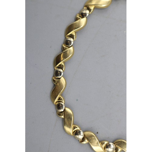 14 - Stamped 18ct yellow gold stylised S-link bracelet with interspersed circular links and lobster claw ... 