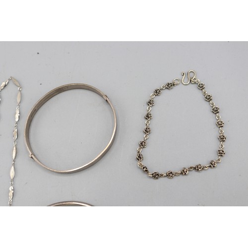 59 - Mixed lot of silver jewellery, comprised of two sterling silver hinged bangles, a sterling silver ma... 