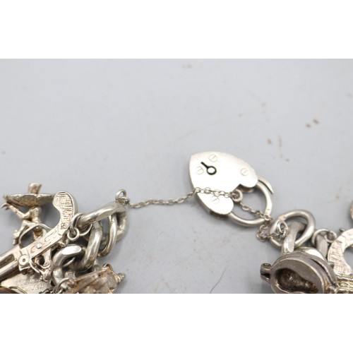 24 - Large, heavy charm bracelet comprising a thick-gauge solid curb link hallmarked sterling silver brac... 