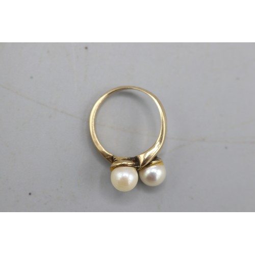 23 - Stamped 9ct yellow gold pearl toi et moi ring, comprising two 6mm pearl beads set to offset twisted ... 
