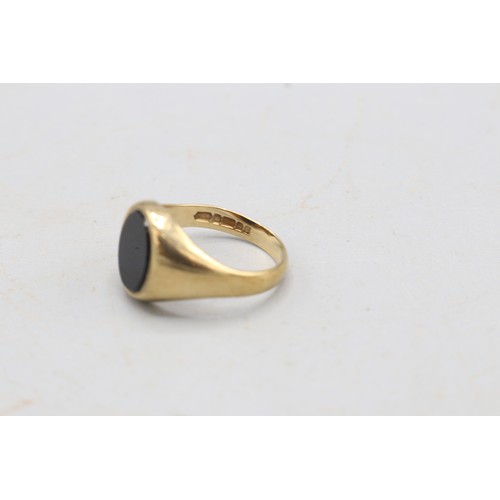 31 - Hallmarked 9ct yellow gold onyx signet ring, comprising a 10 × 7.5mm oval onyx set within a plain ta... 